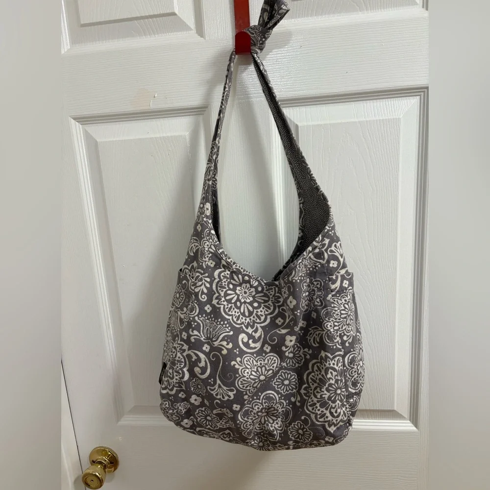 Thirty-One Retro Metro Hobo Crossbody in a gray floral and reverses to gray dots